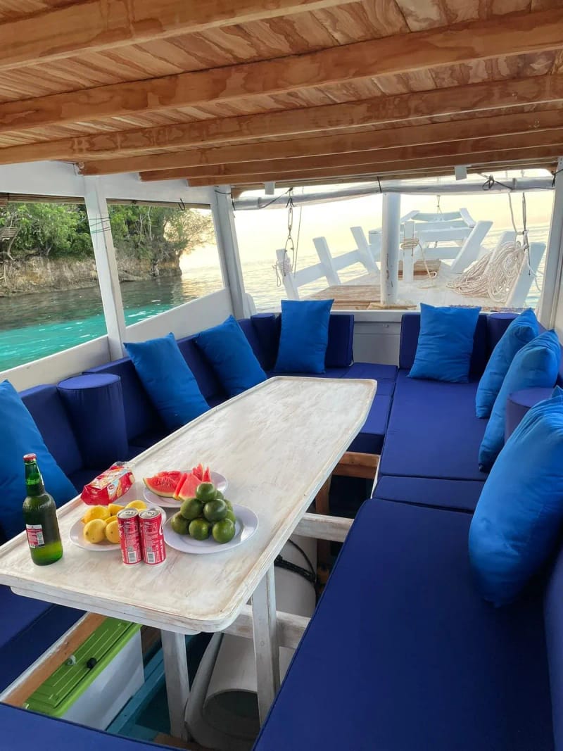 Fresh watermelon, limes and drinks on a table in a boat’s shaded lounge